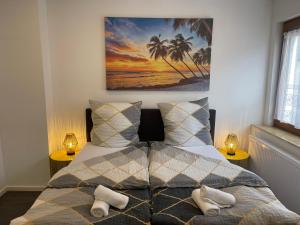 a bedroom with a bed with two lamps and palm trees at Gemütliches Apartment in Geisenheim in Geisenheim