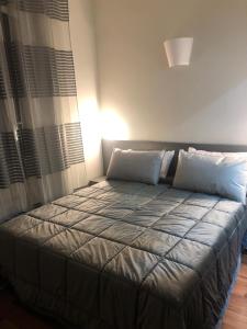 uma cama com duas almofadas num quarto em ALMA Rooms Appia em Roma