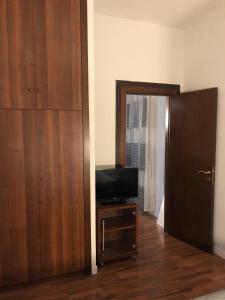 um quarto com uma televisão e um armário de madeira em ALMA Rooms Appia em Roma