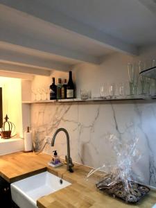 昂德尔Grade II listed Cottage in Oundle with private courtyard的厨房配有水槽和带酒杯的吧台