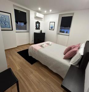 a bedroom with a bed and two windows at Alojamento Cabeço de Vide in Cabeço de Vide