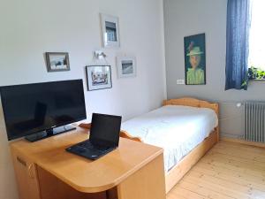 a bedroom with a desk with a laptop and a bed at Comfy and central in Bohinj