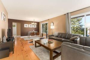 sala de estar con sofá y mesa en Stunning Rustic Vacation home with180-degree Mountain View en Abbotsford