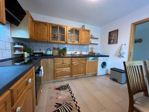 a kitchen with wooden cabinets and a washer and dryer at Ferienwohnung Panorama Oberkirn in Oberkirn