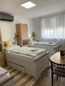 a bedroom with two beds and a table with a tableablish at Kuća za odmor Erdelji in Vardarac