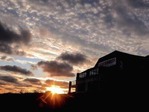 a sunset with the sun setting behind a building at Beach House B&B in Bude