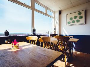 a dining room with a table and chairs and a window at Beach House B&B in Bude