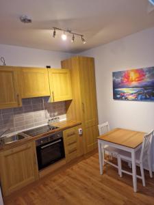 a kitchen with wooden cabinets and a table and a dining room at Dublin's Fair City Apartment in Dublin