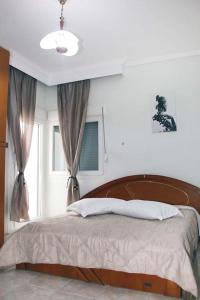 a bedroom with a bed with a wooden headboard and a window at Blue swing chair apartment in Perea +25 photos