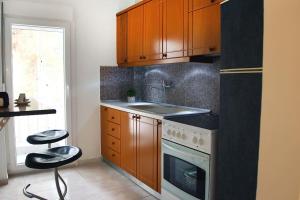 a kitchen with wooden cabinets and a stove top oven at Blue swing chair apartment in Perea