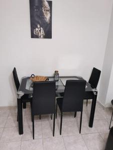 a dining room table with black chairs and a cat on it at Blue swing chair apartment in Perea