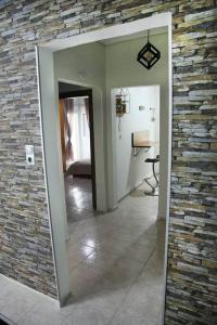 a hallway with a stone wall and a mirror at Blue swing chair apartment in Perea