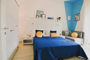 ein Schlafzimmer mit einem blauen Bett und einem Sofa in der Unterkunft La Terrazza Family Holidays, Sorrento Coast in Sant'Agnello