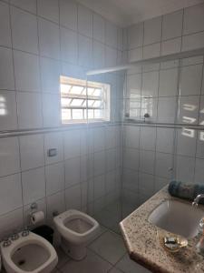 Repouso Real Rio Preto في ساو جوزيه دو ريو بريتو: حمام ابيض مع مرحاض ومغسلة