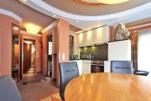 kuchnia z drewnianym stołem i niebieskimi krzesłami w obiekcie Grütter Luxury Apartments w mieście Ischgl