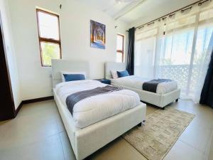 a bedroom with two beds and a couch at Stunning 2 Bed Room Unit with Ocean View in Mariakani