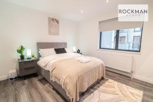 a white bedroom with a bed and a window at Apartment 3 - Brentwood - Spacious Apartment close to High Street, with Free Parking RockmanStays in Brentwood