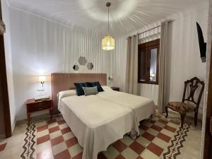 - une chambre avec un grand lit blanc et une chaise dans l'établissement LA BUENA ESTRELLA, à Arbuniel