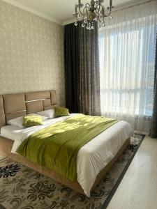 a bedroom with a large bed and a chandelier at PROMENADE EXPO in Prigorodnyy