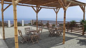 - un pavillon en bois avec des tables et des chaises et l'océan dans l'établissement CASA DE PLAYA Todo el año, à Punta Negra