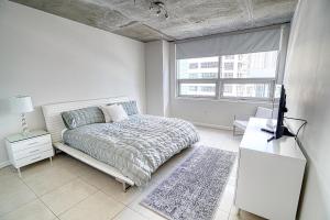 um quarto branco com uma cama e uma janela em Prime Location: Midtown Miami Finest Condo em Miami