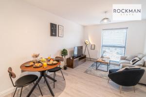 a living room with a table and a couch at Spacious Apartment close to High Street, with Free Parking RockmanStays - Apartment 3 in Brentwood