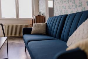 ein blaues Sofa im Wohnzimmer mit Kissen in der Unterkunft 5 min Apartment in Banja Luka