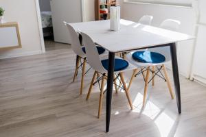 a white table and chairs in a room with wood floors at 5 min Apartment in Banja Luka