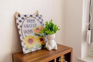 eine Vase auf einem Tisch mit Kissen und Blumen in der Unterkunft 5 min Apartment in Banja Luka