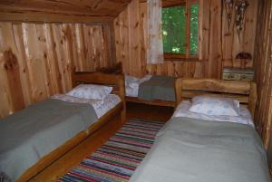 Kiduliai的住宿－Kaimo turizmo sodyba Kukarskė，小木屋内一间卧室,配有两张床