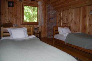 Kiduliai的住宿－Kaimo turizmo sodyba Kukarskė，小木屋内一间卧室,配有两张床