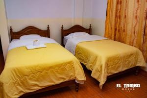 two beds with yellow covers in a room at HOTEL EL TAMBO in Chachapoyas