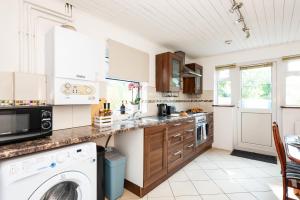 een keuken met een wasmachine en droger bij Single Room with a shared Kitchen and bathroom in a 5-Bedroom House at Hanwell in Hanwell