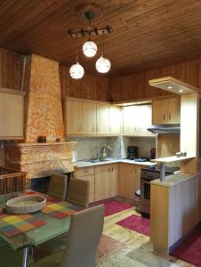 a kitchen with wooden cabinets and a table in it at family home in Dimitsana