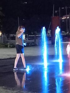 a woman standing in front of a fountain at night at Hatea Drive Accommodation in Whangarei