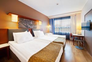 um quarto de hotel com duas camas e uma secretária em Holiday Inn Tampere - Central Station, an IHG Hotel em Tampere