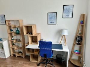 a desk with a blue chair in a room with shelves at Le rêve Bleu in Thionville