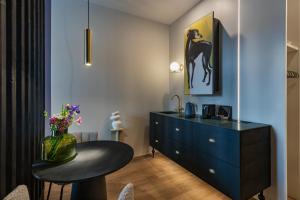 Habitación con cómoda azul y mesa con escritorio. en kalm stay - a design Aparthotel, en Múnich