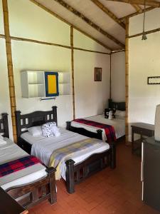 a room with three beds in a room at Finca Hotel La Esmeralda Casa 2 in Calarcá