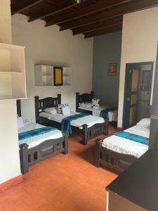 a room with three beds in a room at Finca Hotel La Esmeralda Casa 2 in Calarcá