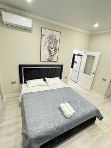 um quarto com uma cama grande com duas toalhas em Жк DIAL RESIDENCE возле Арбата и Мега центра em Almaty