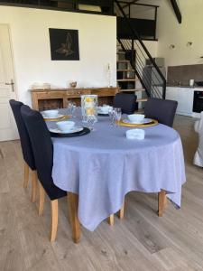 a dining room table with a blue table cloth and chairs at « La Crécerelle » spacieux gîte contemporain entre Tarn et Aveyron in Sainte-Gemme