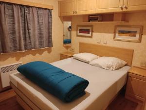 uma cama grande com uma almofada azul em Mobil home willerby de luxe em Le Portel