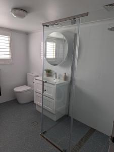 een badkamer met een douche, een wastafel en een toilet bij Totally Beachin! - walking distance to the beach in Eden