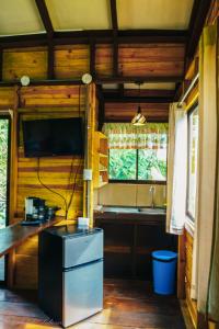 a kitchen with a sink and a tv in a room at Hospedaje La Naciente in Turrialba