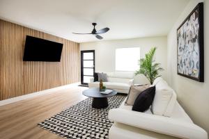a living room with a white couch and a tv at Black Vanilla - Stylish Symphony 3miles Downtown in Naples