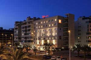 Un edificio con un cartel encima por la noche. en Ibis Elche, en Elche