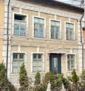 uma casa antiga com janelas e uma porta azul em Like Hostel em Chişinău
