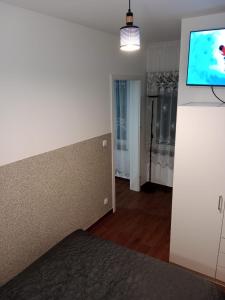 uma sala de estar com uma televisão na parede em Gościnne mieszkania M2 em Białystok