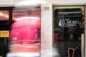 eine Person läuft vor einem Ladenfenster in der Unterkunft Hotel Il Moro di Venezia in Venedig